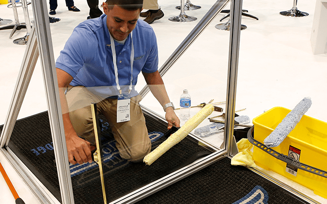 Man demoing glass cleaner on the ISSA Show Expo Hall Floor