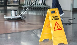 Commercial Cleaning Worker with Wet Floor Sign